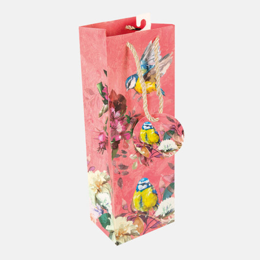 Decorative wine bottle bag with bird and floral design on a pink background