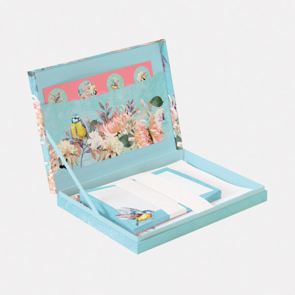 Floral and bird design notebook with a pen on a light gray background