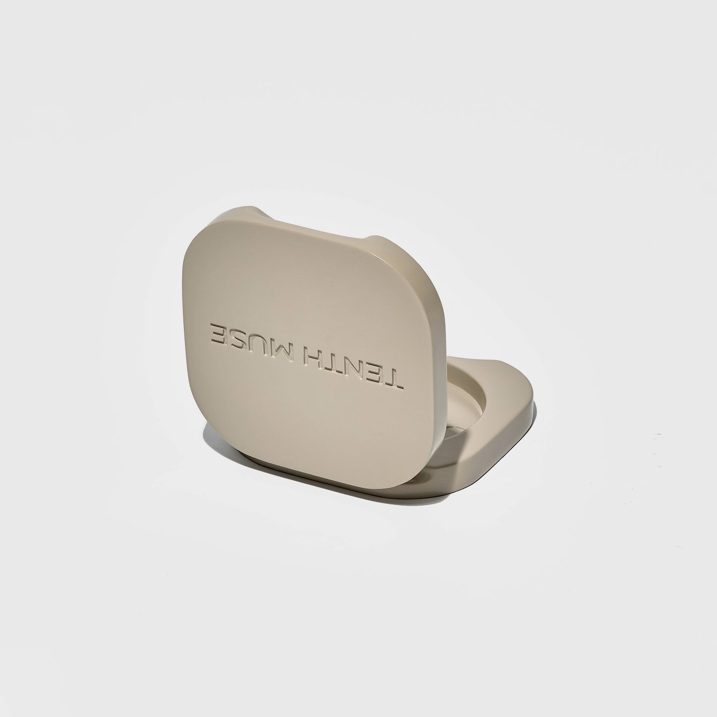 Tenth Muse Clay coloured metal case stand with 'TENTH MUSE' branding on a light gray background