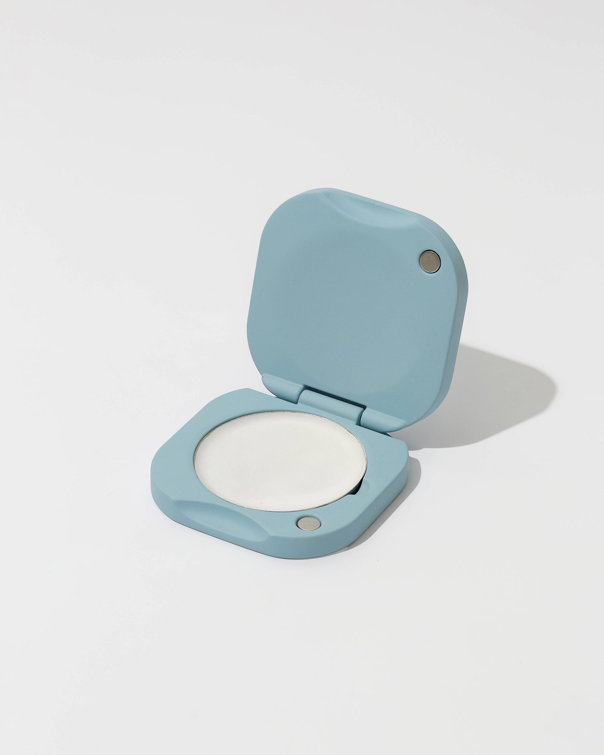 Compact powder in a light blue case on a white background