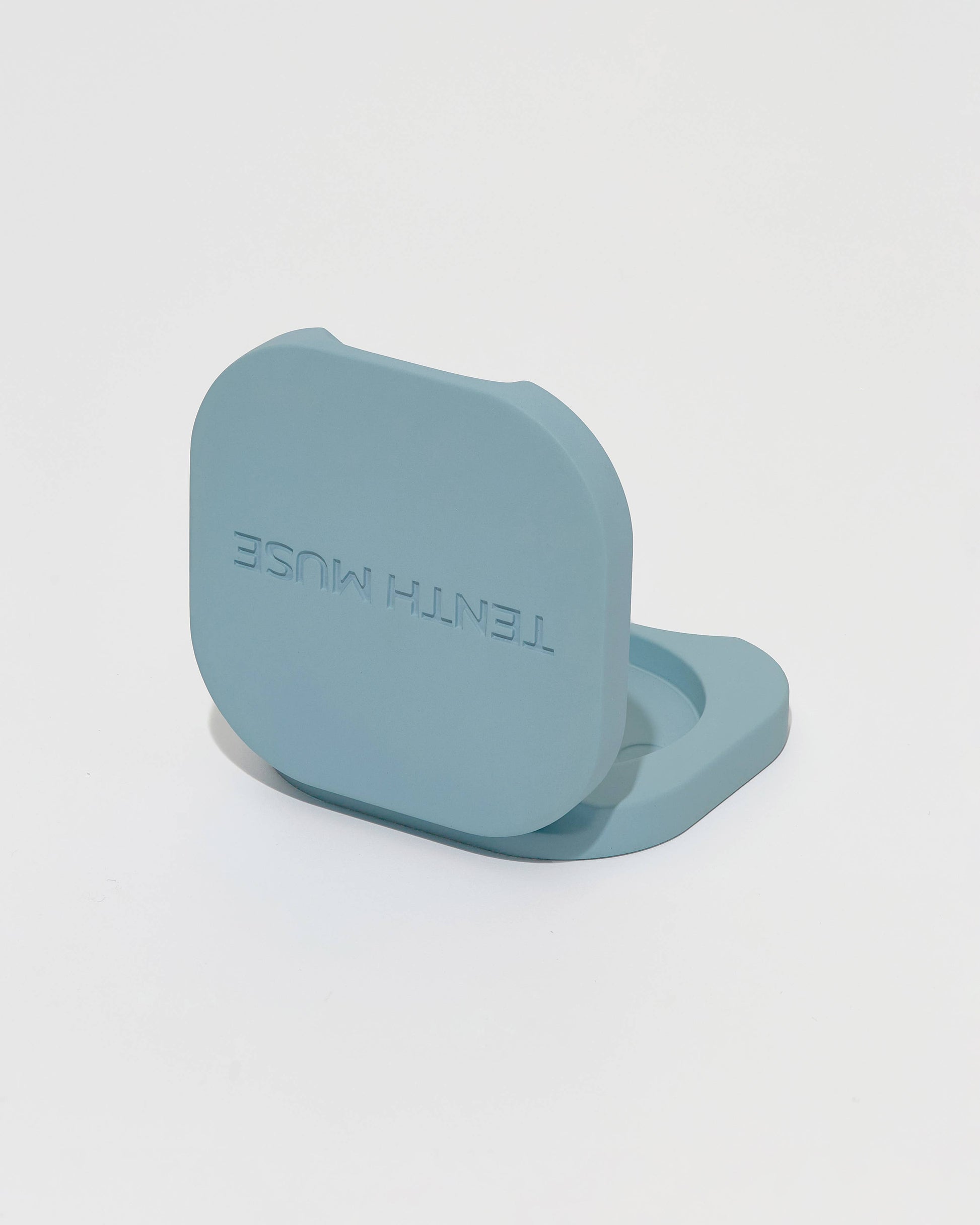 Bkue metal perfume balm holder with 'TENTH Muse' branding on a light gray background
