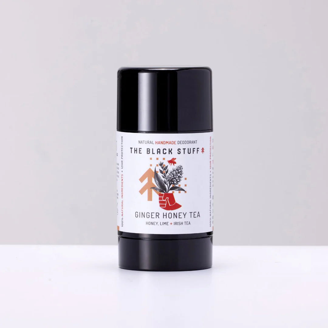 Deodorant stick labeled 'The Black Stuff' with a ginger honey tea flavor on a white background