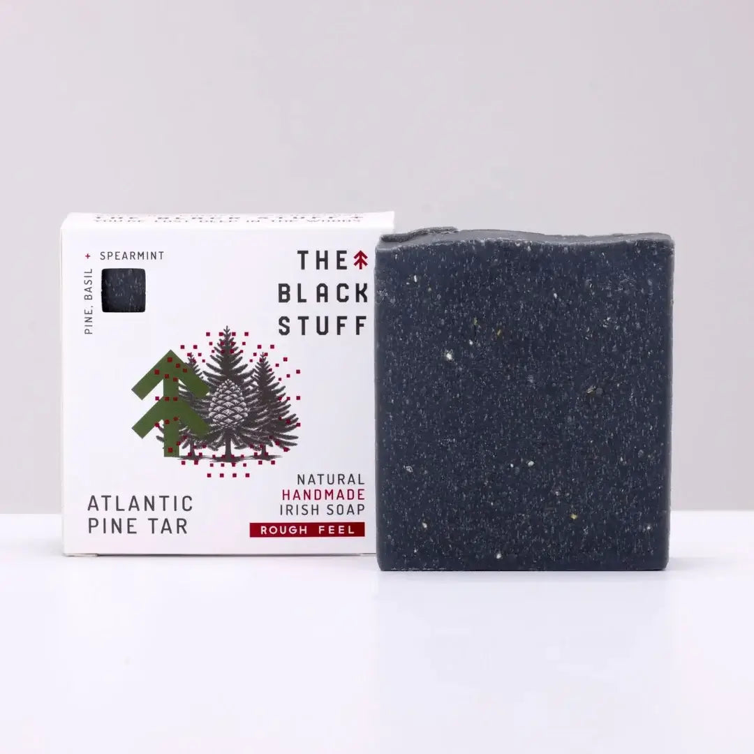 Packaging for 'The Black Stuff' Atlantic Pine Tar bar soap, featuring the product name, a small amount of soap, and a rough feel description.