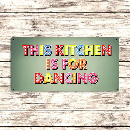 Decorative sign with colorful text 'THIS KITCHEN IS FOR DANCING' on a wooden background