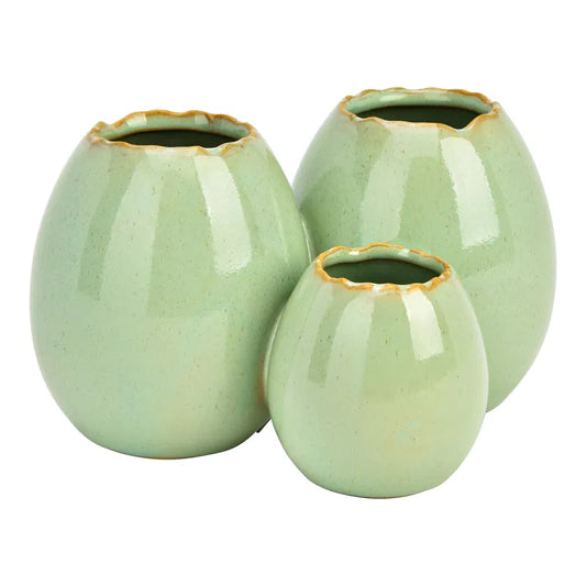 Three light green ceramic vases with gold rims on a white background