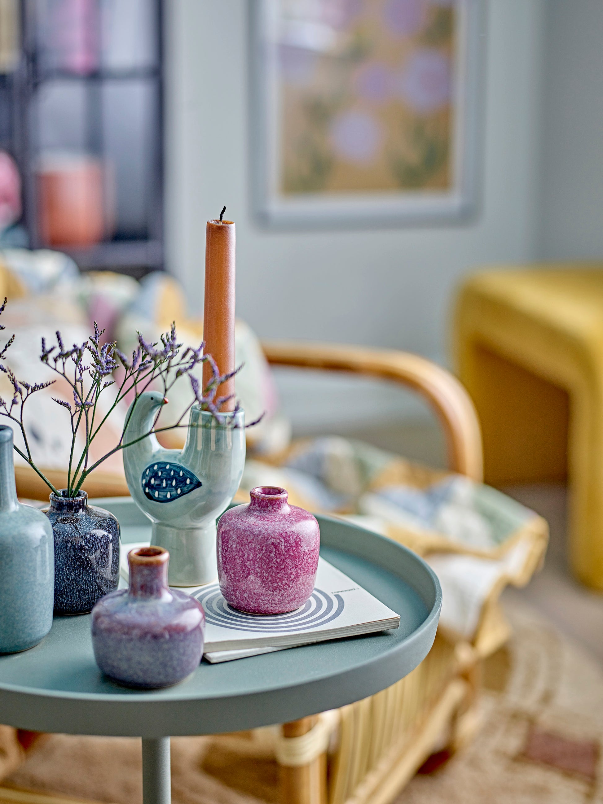 Decorative table with vases and a candle in a home setting