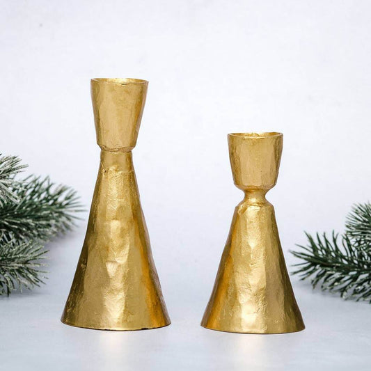 Two gold coloured candle sticks on festive background