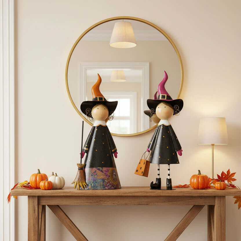 Two decorative witch figurines with colorful hats and brooms on a hall table