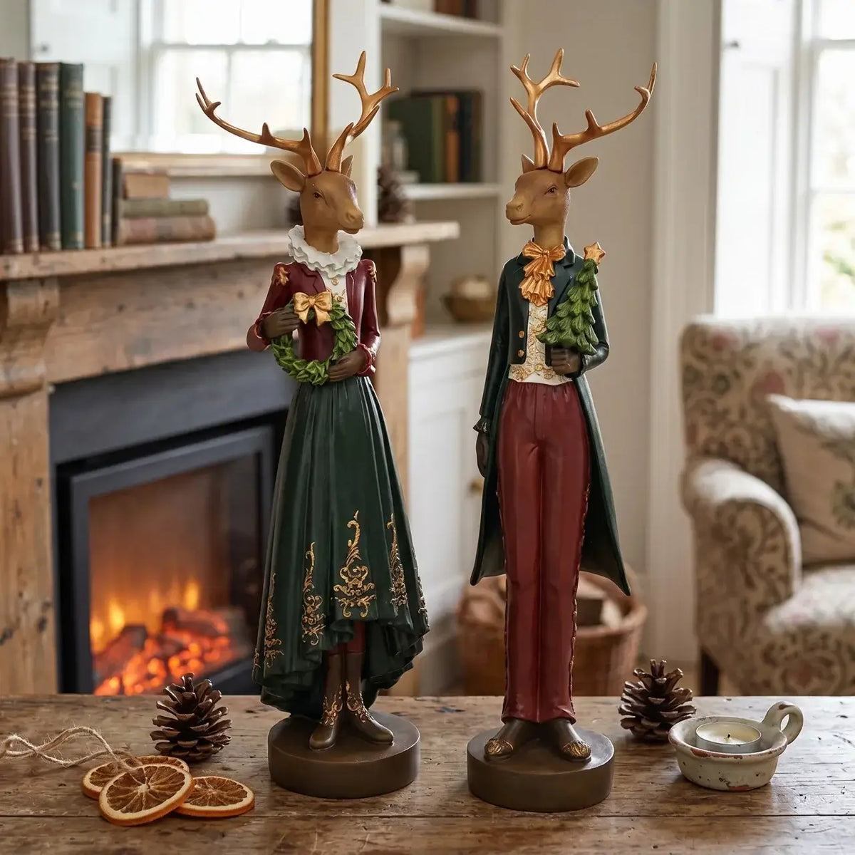 Two deer figurines in formal attire standing on a wooden table with a fireplace and books in the background.