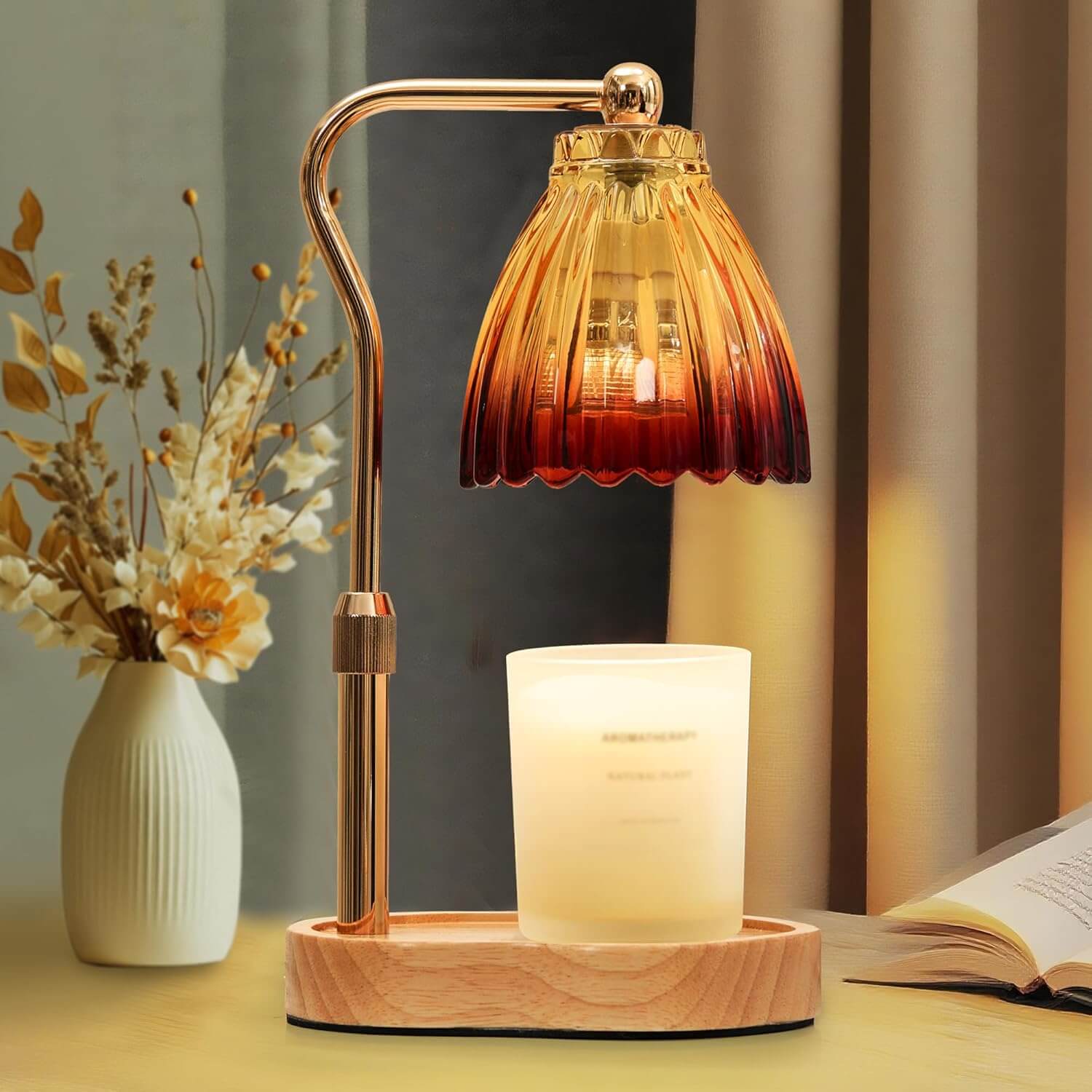 Decorative table lamp with a warm glass shade next to a candle and vase on a surface.