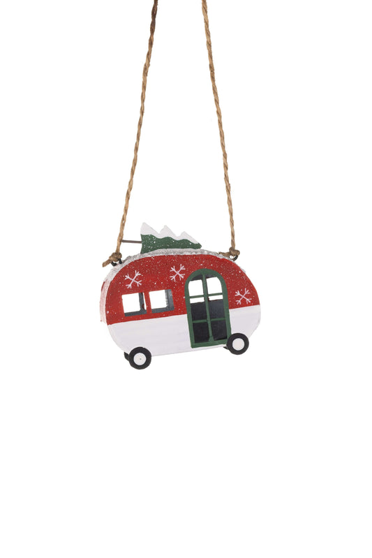 A small hanging ornament shaped like a vintage trailer or camper, with a red upper section, white lower section, dark green door and window trim, black wheels, and a brown hanging rope against a plain white background.