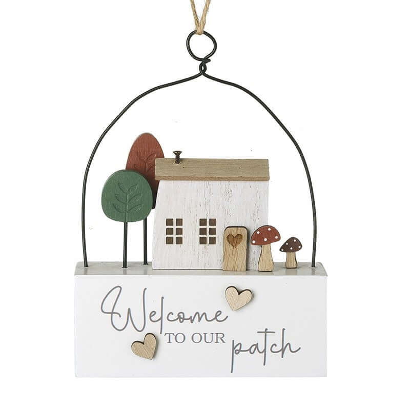 Decorative hanging sign with a house, trees, and mushrooms on a white background