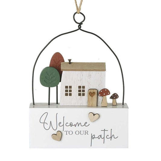 Decorative hanging sign with a house, trees, and mushrooms on a white background