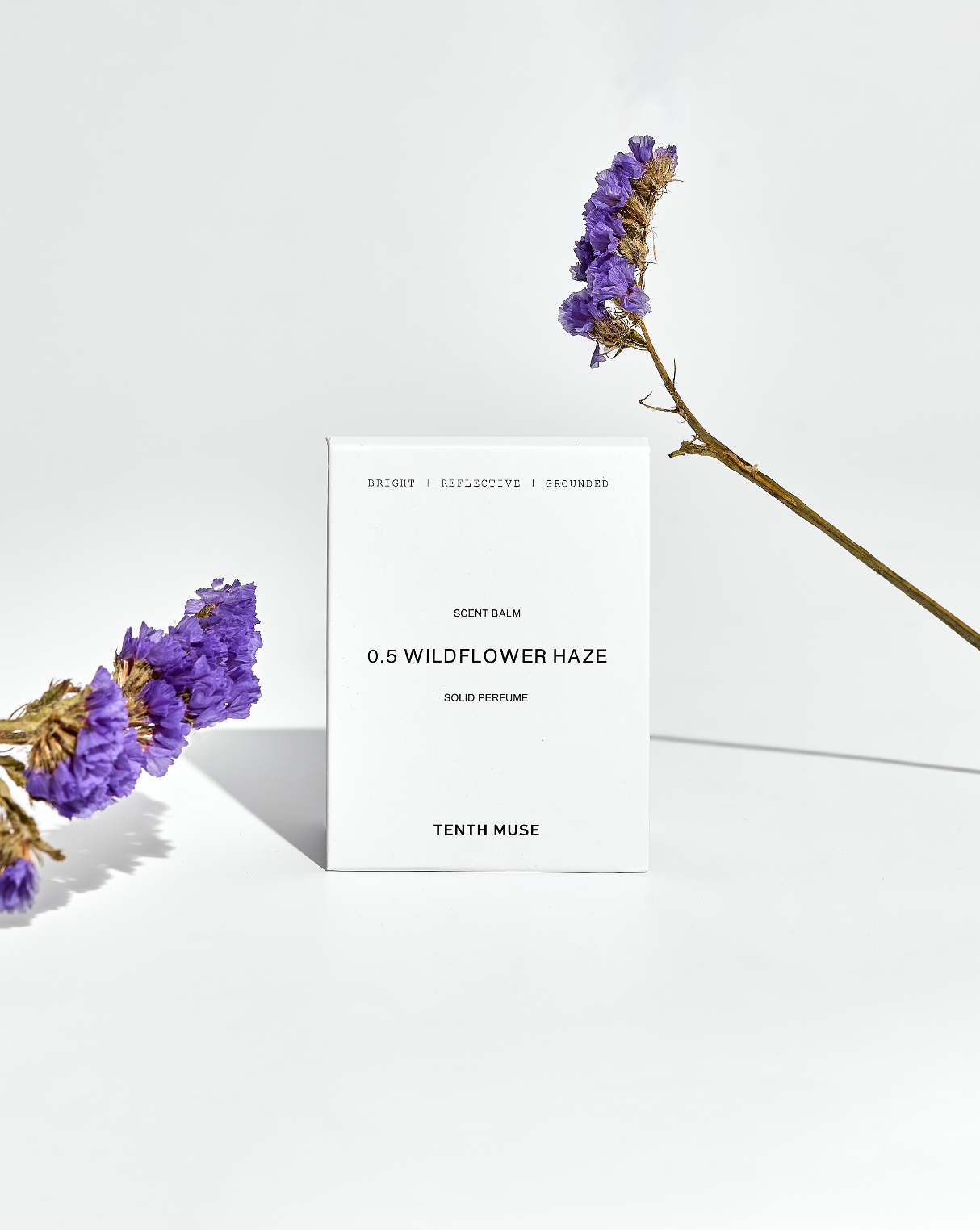Solid perfume packaging with purple flowers on a white background