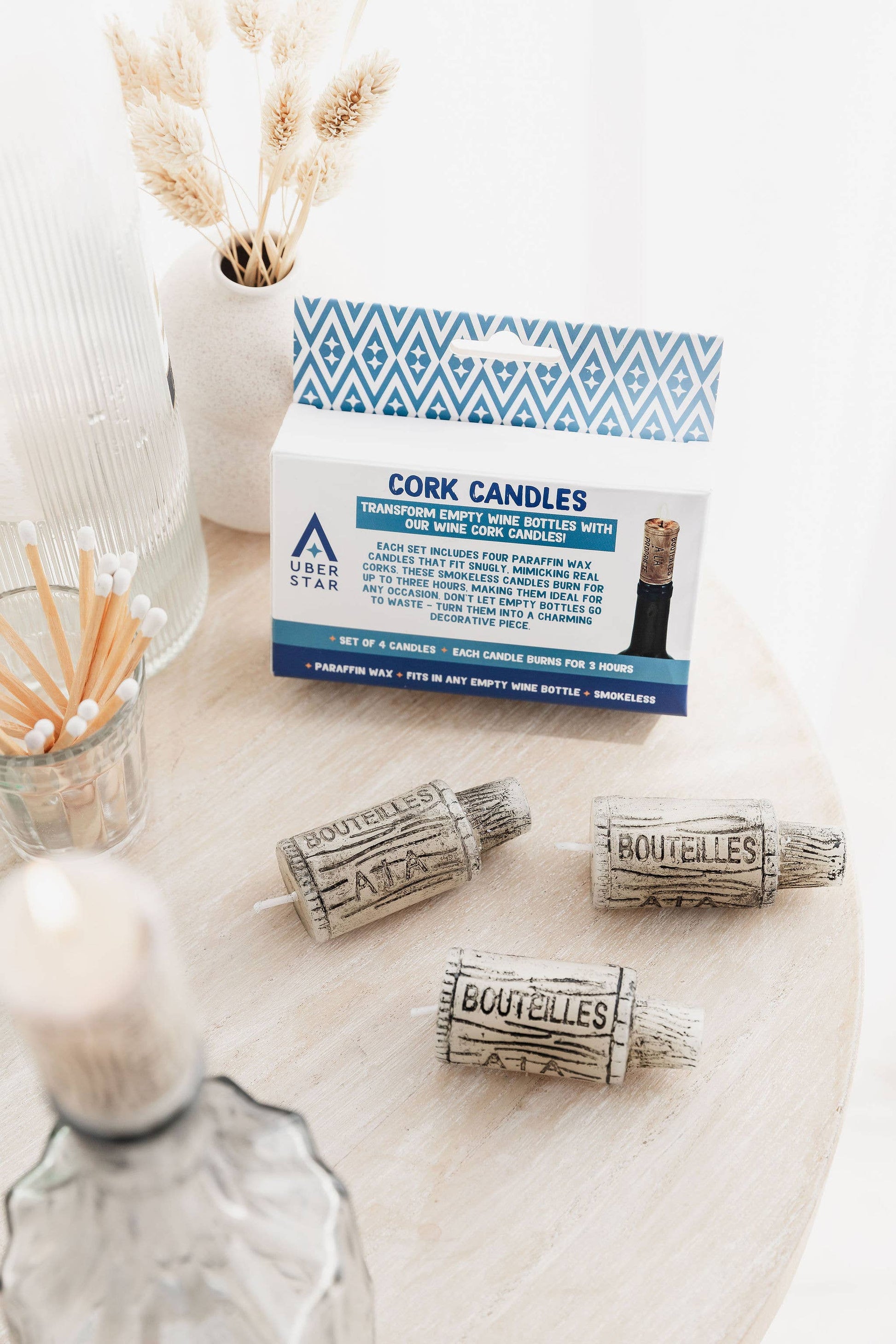 Cork candles with packaging on a marble surface