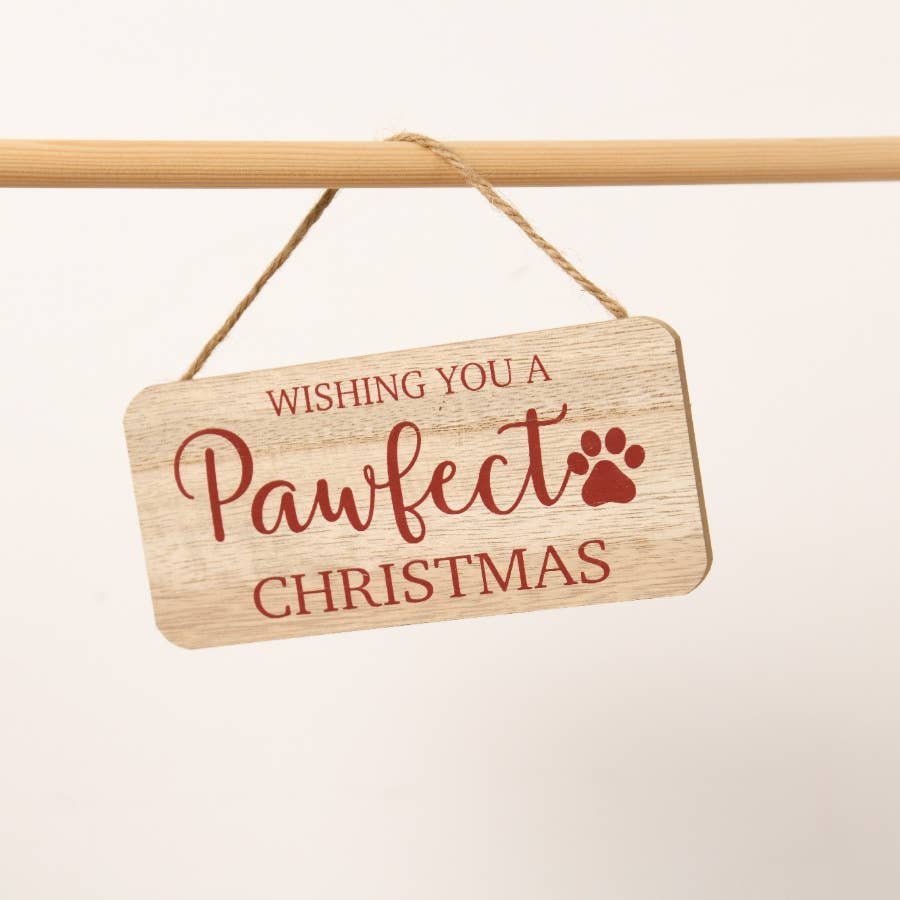Wooden sign with 'Wishing you a pawfect Christmas' text on a beige background