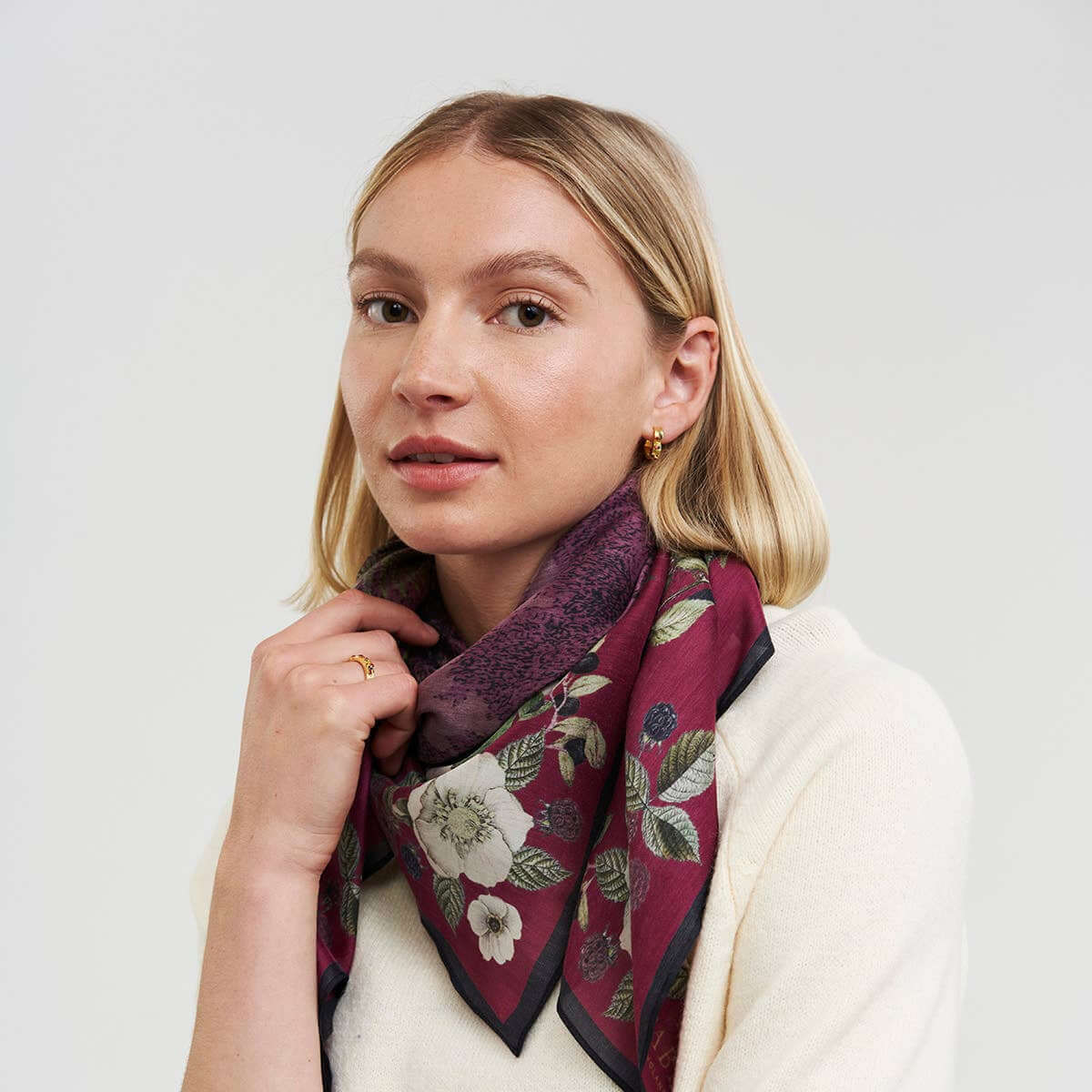 Woman wearing a floral scarf on a white background