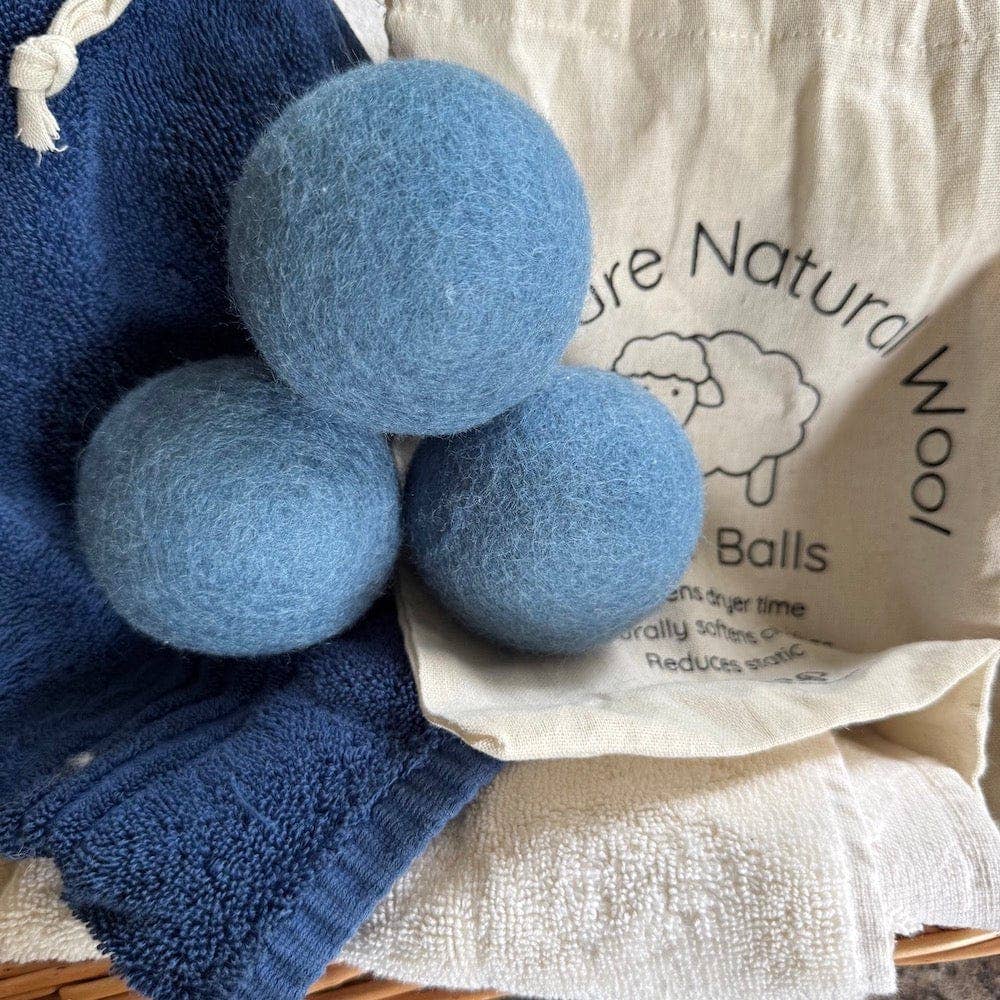 Three blue wool balls with a branded bag in the background