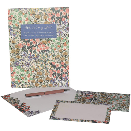 A floral writing set including a notebook, envelope, stationery cards, and a pen, all decorated with a dense multicolor botanical pattern on a white background.