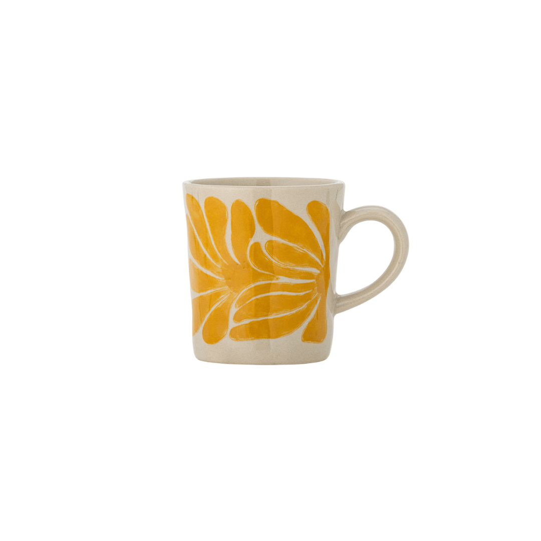 A ceramic coffee mug with a bold yellow floral pattern on a cream-colored background, featuring a C-shaped handle on the right side.