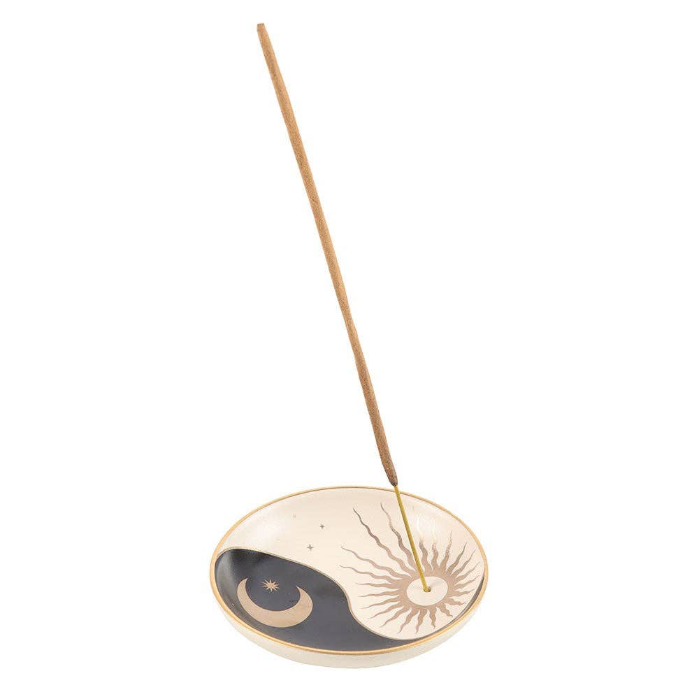 Incense stick with a decorative dish featuring celestial designs on a white background