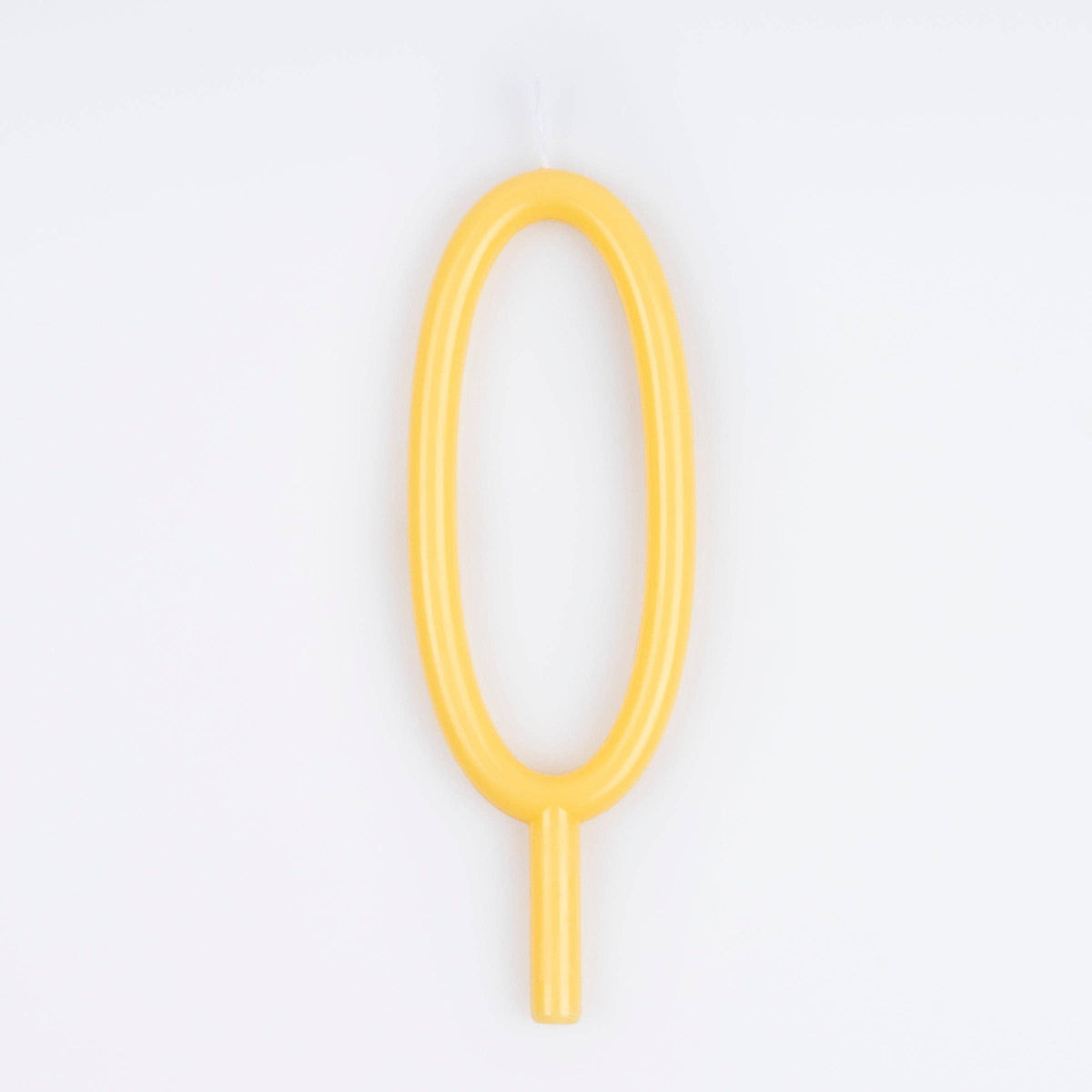 A single yellow novelty birthday candle shaped like a zero, shown against a plain white background.