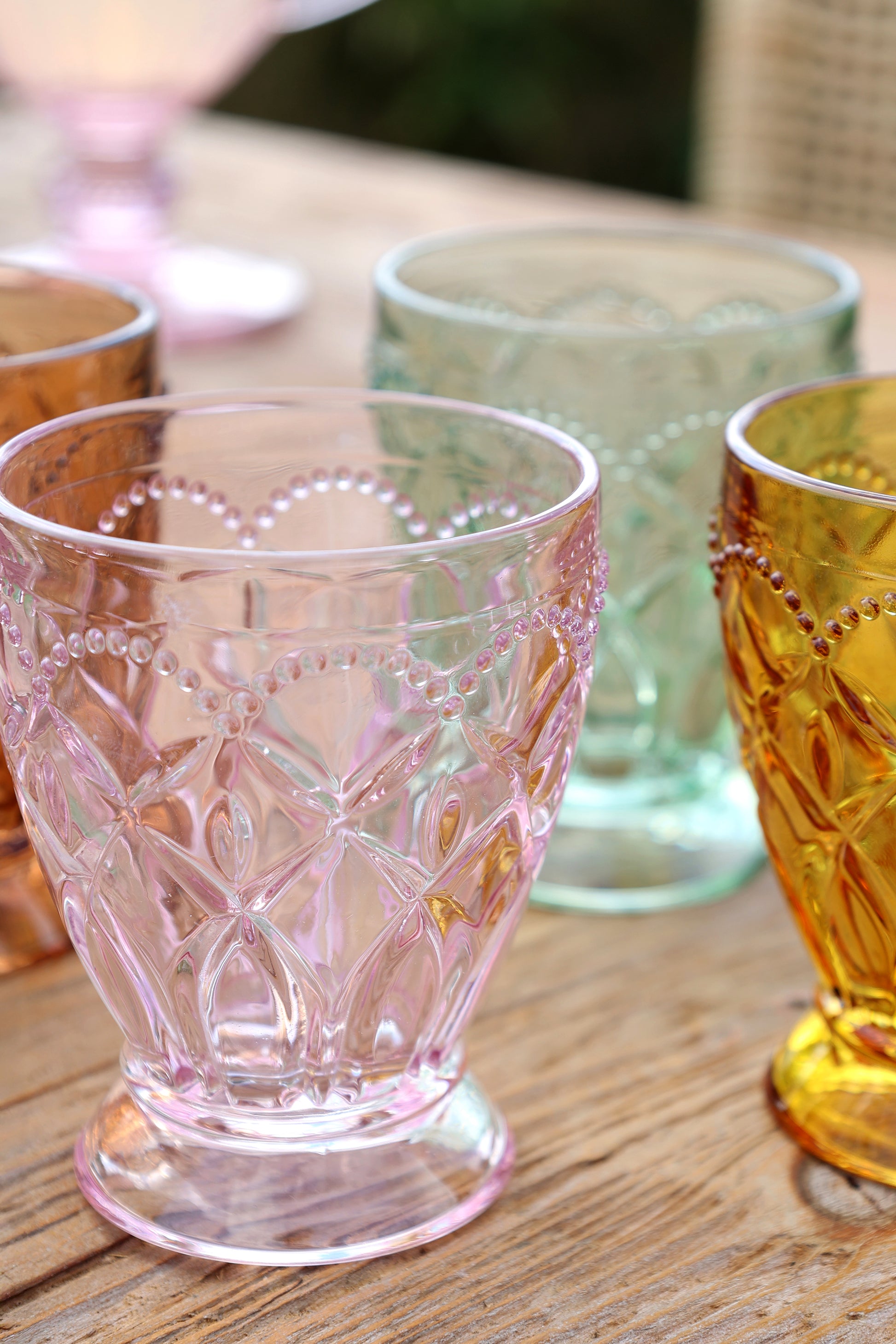 Set of colorful glass tumblers on a wooden surface