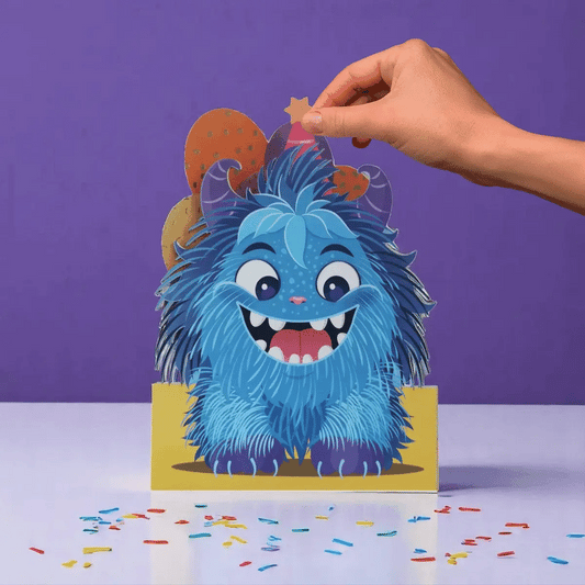 Hand interacting with a blue furry creature card on a purple background