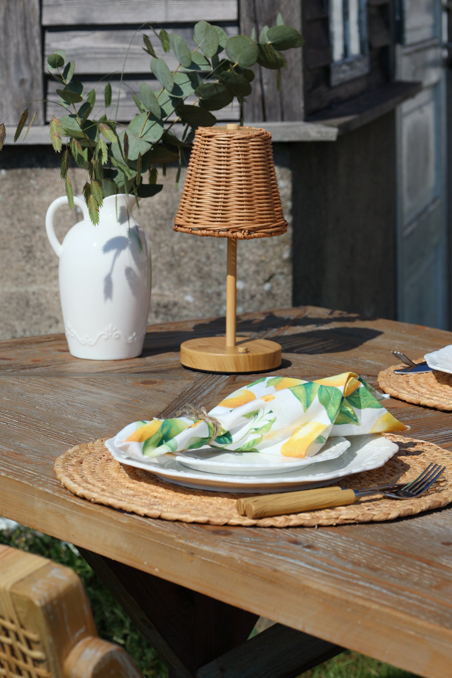 Outdoor setting with a wooden table, lamp, and decorative items.